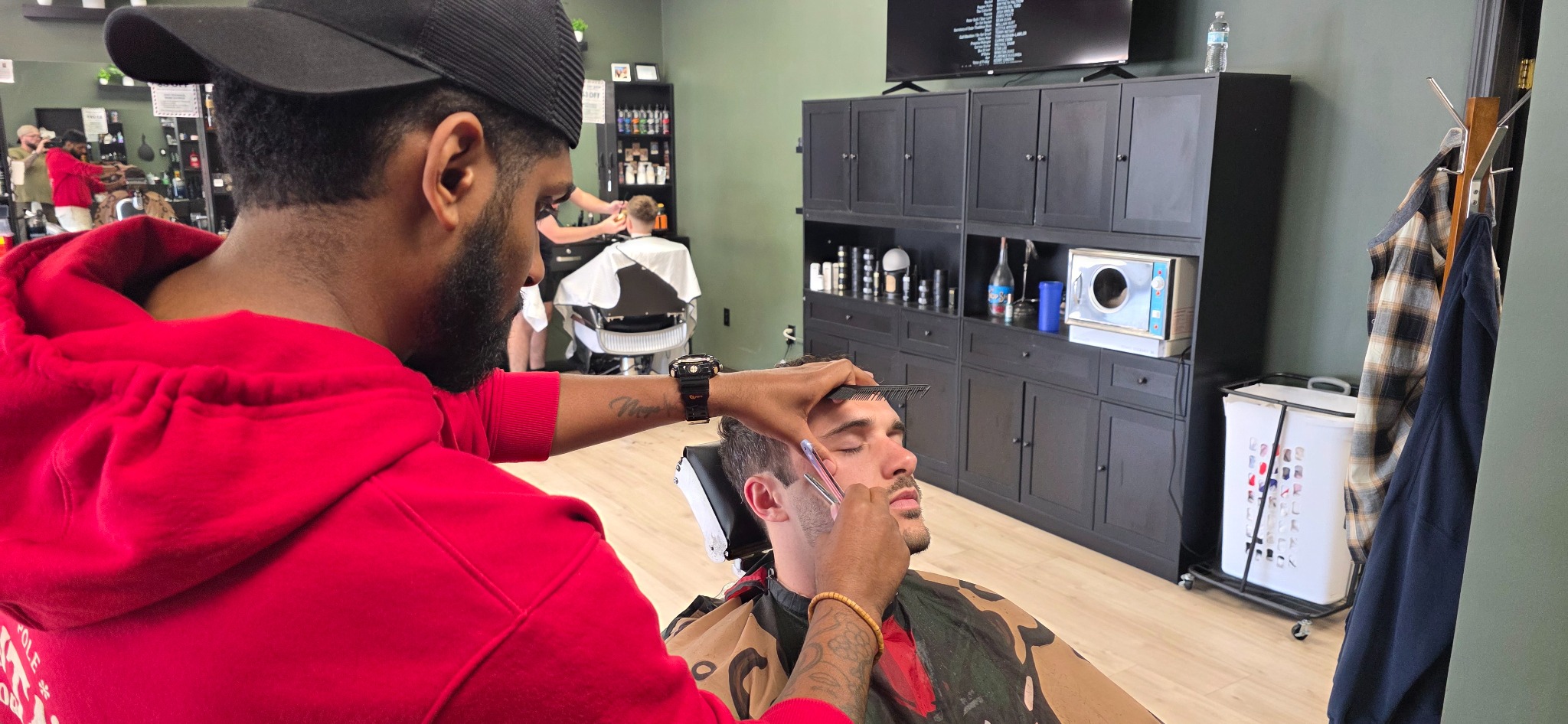 A Chop Shop barber performing precise straight-razor detail work